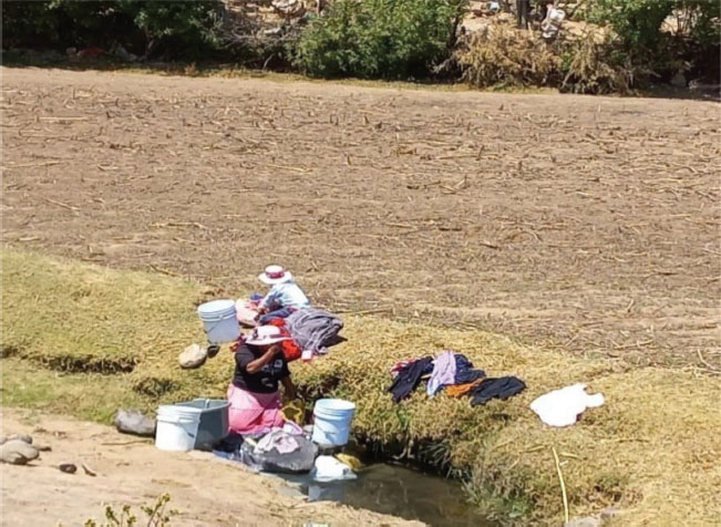Figura 3. Mujer mazahua lavando sobre un arroyo